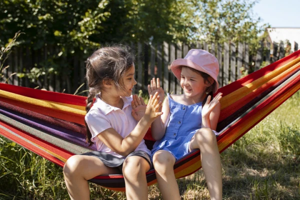 sfeerbeeld kids hangmat kleuren hoedje gras stock